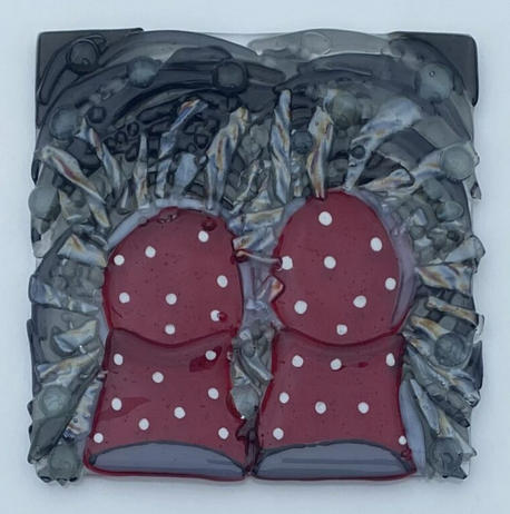 A pair of red welling boots with white spots splash into a puddle of water as seen from the point of view of the person wearing them.